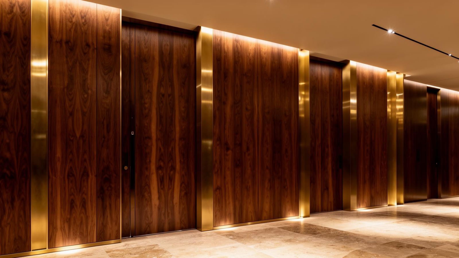 Luxury hotel corridor with full-height walnut veneer doors, bookmatched oak veneer wall paneling and brushed brass reveals